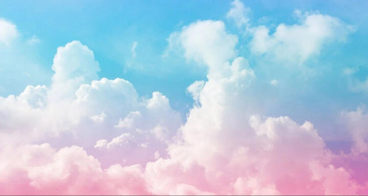 Large clouds in the sky. The clouds are a gradient from pink at the bottom to blue at the top.