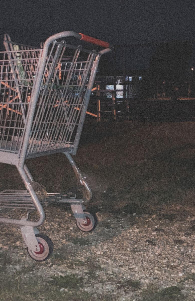A photo with the flash on. There is a shopping cart half out of frame on the left side. It is night time.